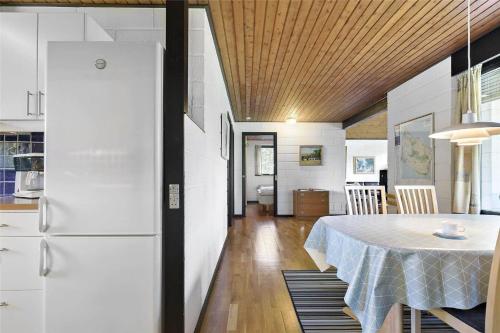 a kitchen and dining room with a table and a refrigerator at 2689-Nexo-Munkegardsskoven-6 in Neksø