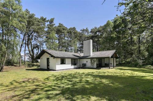 a small white house in the middle of a yard at 2689-Nexo-Munkegardsskoven-6 in Neksø