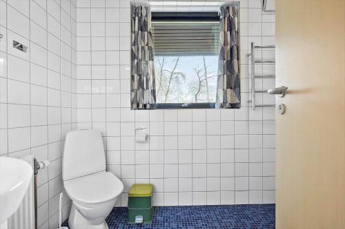 a white bathroom with a toilet and a window at 2689-Nexo-Munkegardsskoven-6 in Neksø