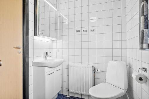 a white bathroom with a toilet and a sink at 2689-Nexo-Munkegardsskoven-6 in Neksø