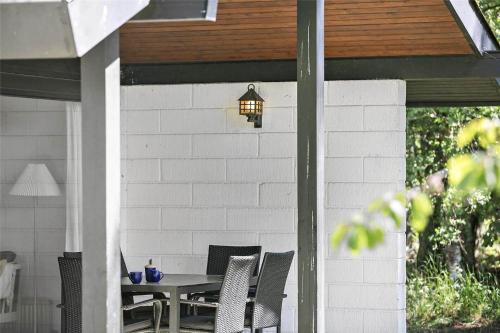 a patio with a table and chairs and a lamp at 2689-Nexo-Munkegardsskoven-6 in Neksø