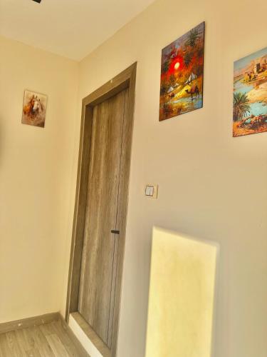 a door in a room with paintings on the wall at Kemet Aurora Pyramds View in Cairo