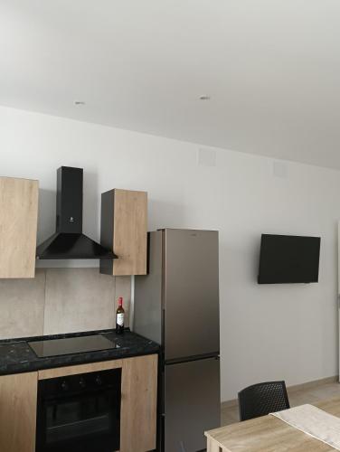 a kitchen with a stainless steel refrigerator and a table at Wellness House in Bagheria