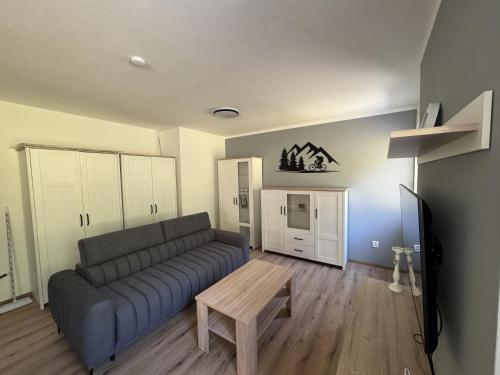 a living room with a couch and a table at Apartmán Rusava in Rusava