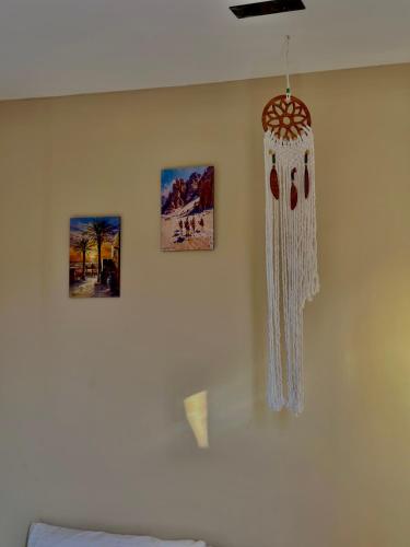 a room with a white wall with pictures on it at Kemet Aurora Pyramds View in Cairo
