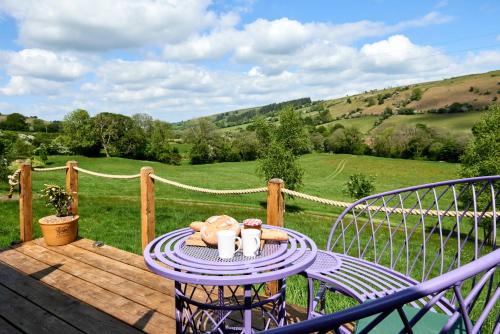 a purple table with food on it on a deck at The Flying Scotsman Shepherd's Hut with Hot Tub in Brecon