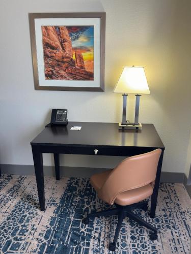 a desk with a lamp and a chair in a room at La Quinta by Wyndham Moab in Moab