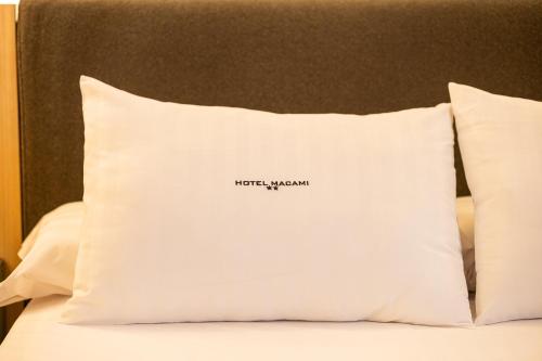 a pillow with a word on it sitting on a bed at Hotel Macami in El Carpio