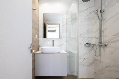 a white bathroom with a sink and a shower at Emmanouil Private Villa A in Roumelí