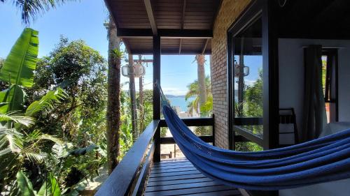 a blue hammock on a porch of a house at Pousada Palmeiras Bombinhas in Bombinhas