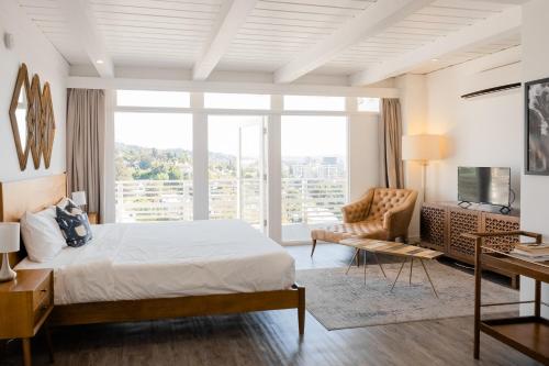 a bedroom with a bed and a desk and a large window at Hollywood Hills Hotel in Los Angeles