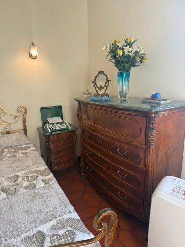a bedroom with a dresser with a vase of flowers on it at Re di Roma Rooftop in Rome