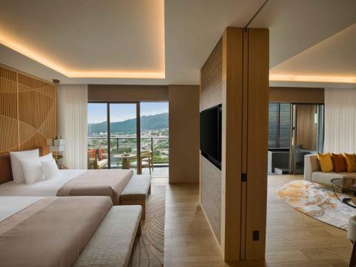 a hotel room with two beds and a television at ANA InterContinental Beppu Resort & Spa by IHG in Beppu