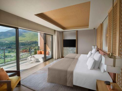 a bedroom with a large bed and a large window at ANA InterContinental Beppu Resort & Spa by IHG in Beppu