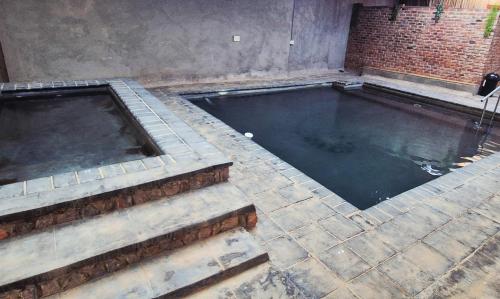 a pool of water with a brick wall at Hide Away Wedding,Conference & Function Venue in Bela-Bela