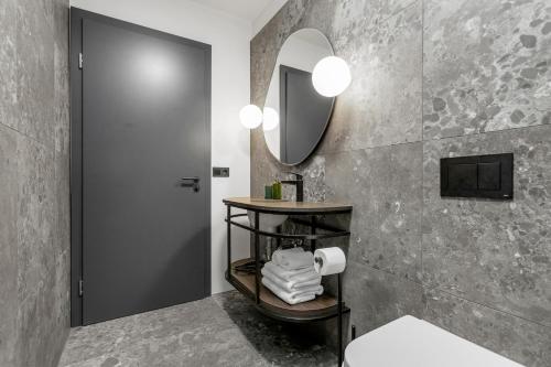 a bathroom with a sink and a mirror at Strand Hotel Apartments in Hafnarfjördur