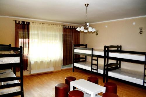 a room with four bunk beds and a table at Hostel Art Gradiska in Bosanska Gradiška
