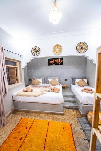 a bedroom with two beds and a fireplace at KOUTOBIA ROYAL in Marrakech