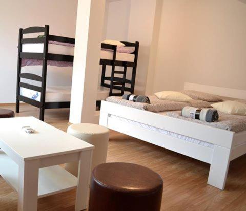 Schlafzimmer mit einem Bett, einem Tisch und Stühlen in der Unterkunft Hostel Art Gradiska in Bosanska Gradiška