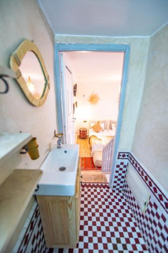 a bathroom with a sink and a room with a bed at KOUTOBIA ROYAL in Marrakech
