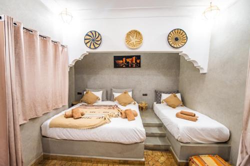 two beds in a room with clocks on the wall at KOUTOBIA ROYAL in Marrakech