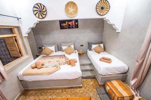 two beds in a room with clocks on the wall at KOUTOBIA ROYAL in Marrakech