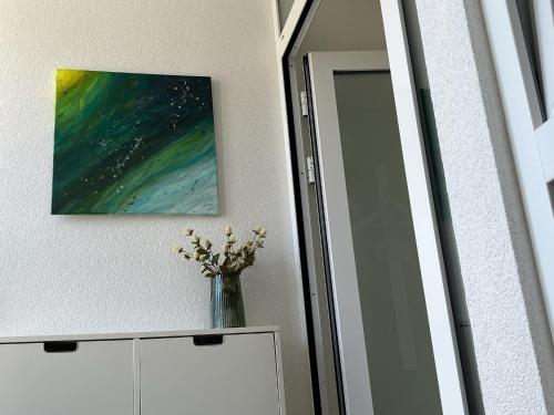 a vase of flowers on a dresser next to a mirror at Zum See 2 in Losheim