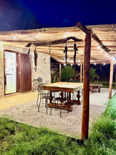 a table and chairs under a wooden pergola at Le Tre Aie in San Giovanni a Piro