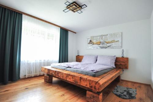 a bedroom with a wooden bed and a large window at Dein Ferienhaus in Kärnten, Bad Bleiberg - Erholung, Natur und Komfort in Bad Bleiberg