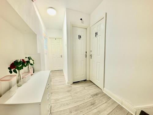 a white hallway with a table and flowers in a vase at Westfield London Shepherds Bush in London