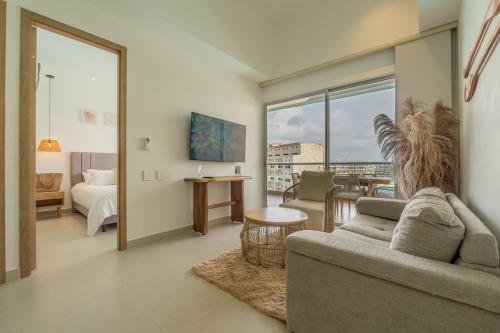 a living room with a couch and a bedroom with a view at Baia Crystal Luxury Stay - Penthouse Vista a la Laguna in Cartagena de Indias