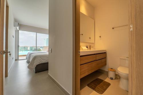 a bathroom with a bed and a sink and a toilet at Baia Crystal Luxury Stay - Penthouse Vista a la Laguna in Cartagena de Indias