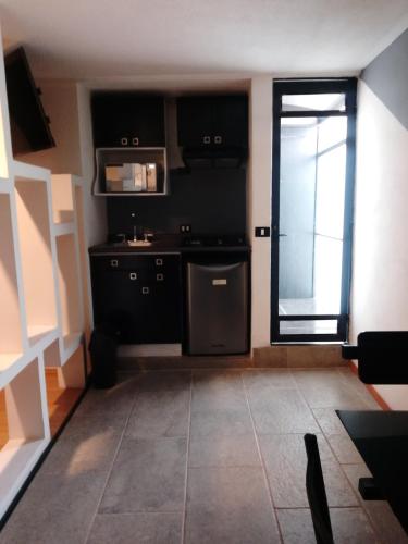 a kitchen with black cabinets and a window at Hotel Business in El Gallinero