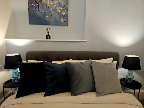 a bedroom with a bed with pillows and a painting at Christchurch House in Folkestone