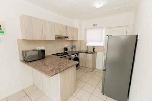 a kitchen with a refrigerator and a counter top at Muizi Hideaway in Muizenberg