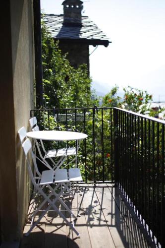 a table and chairs on a balcony with a bird house at VistaStelle in Aosta