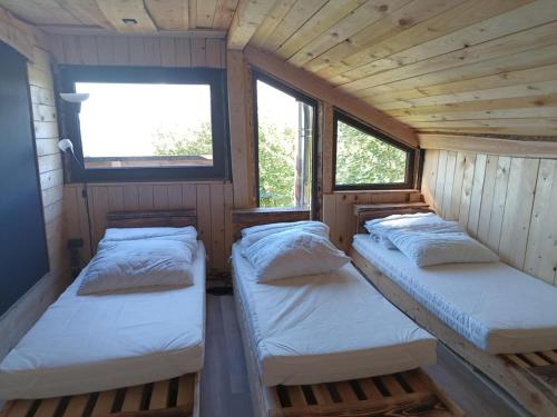 two beds in a room with two windows at Enklawa w Porębie in Długopole-Zdrój