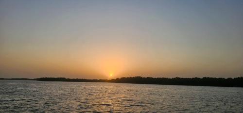 a sunset over a large body of water at FARAFINA KEUR DAMEL Toubakouta in Toubakouta