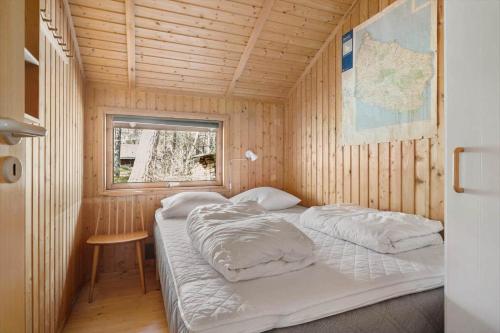 a bedroom with two beds in a wooden cabin at 2544-Nexo-Skovsangervej-29 in Neksø