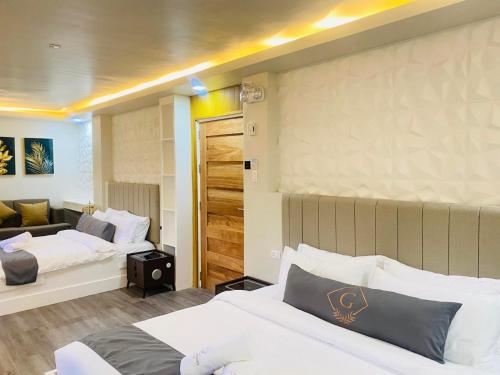 a hotel room with two beds and a couch at Grospe Resort Boracay in Boracay