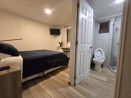 a bedroom with a bed and a toilet at AH Hotel in Antofagasta