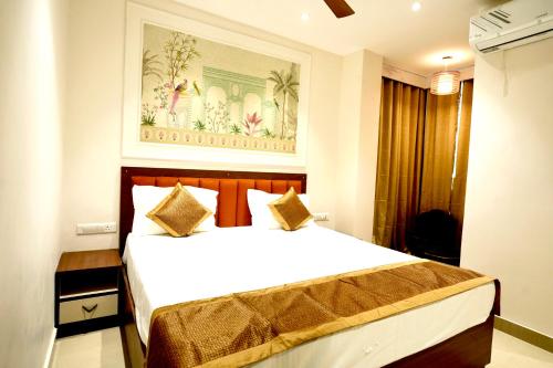 a bedroom with a large white bed and a painting on the wall at Hotel Eraya in Varanasi