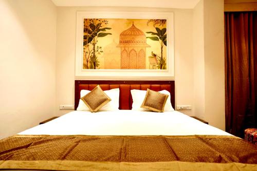 a bedroom with a bed with a picture on the wall at Hotel Eraya in Varanasi