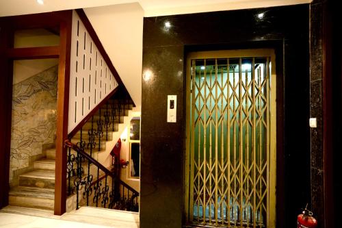 a hallway with a door and a staircase with a stair railing at Hotel Eraya in Varanasi