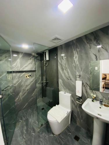 a bathroom with a toilet and a shower and a sink at Grospe Resort Boracay in Boracay