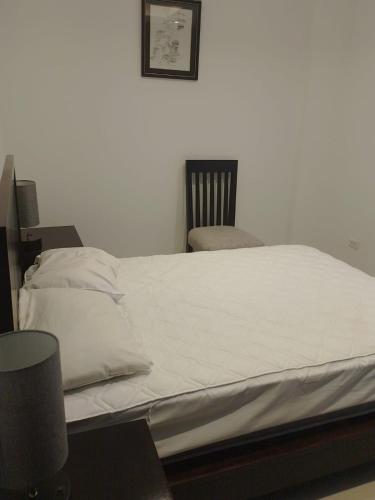 a white bed with a chair in a room at Fontaine Bleau Tonsupa, Ecuador in Volcán Chimborazo