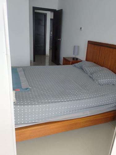 a bed in a bedroom with a wooden frame at Fontaine Bleau Tonsupa, Ecuador in Volcán Chimborazo