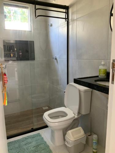 ein Badezimmer mit Toilette und Glasdusche in der Unterkunft Casa dos cajueiros in Paracuru