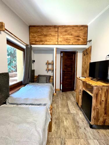 a bedroom with two beds and a flat screen tv at Carp Land Camp in Balatonszepezd