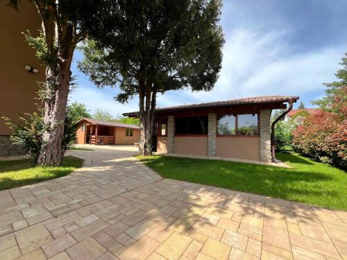 a house with a brick driveway and a tree at Carp Land Camp in Balatonszepezd
